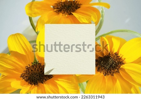 Mockup of a summer greeting card decorated with yellow sunflowers in a glass container