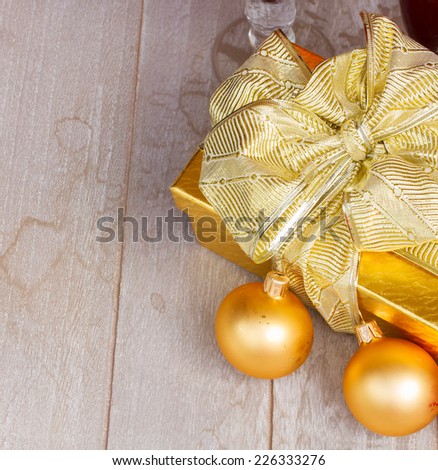 golden  gift box with  christmas decorations on wooden background with copy space