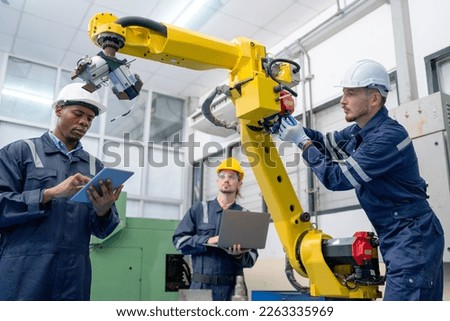 Close up view African American technician work with his team to check and maintenance robotic arm in factory workplace. Royalty-Free Stock Photo #2263335969