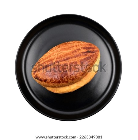Traditional turkish pastry  bun,"pogaca" in a round black plate, isolated on white background, top view