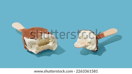 Eaten chocolate ice cream on a stick on blue pastel background