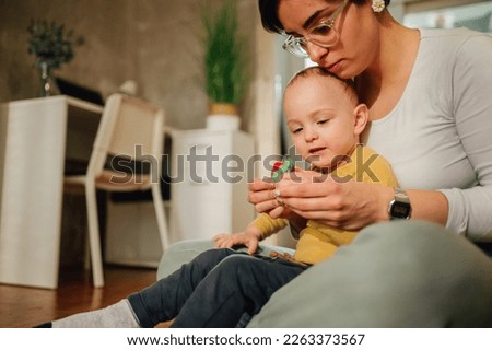 Mother and son molding with clay and improving fine motor skill trough the games. Toddler boy playing with his babysitter or aunt. Funny educational games for children concept. Copy space.