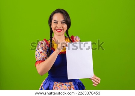 Beautiful woman dressed in typical clothes for a Festa Junina. holding sign for text or ad, advertisement.