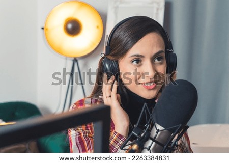 Young woman talking using mic and headphones recording podcast for her audience. High-quality photo