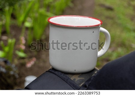 White mug on green nature landscape close up photo