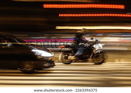 abstract blurred image of a car and a motorcycle on a city street at night Royalty-Free Stock Photo #2263396375