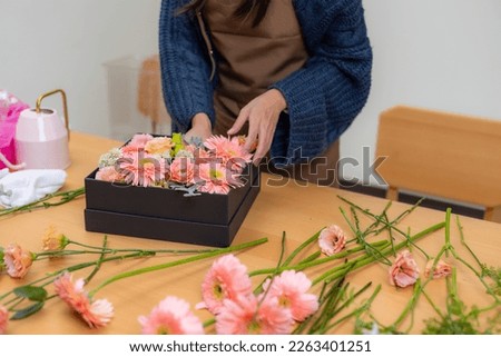 Female florist make a box of flower in workspace