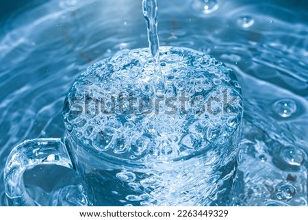 Watching the water overflows of the glass. Royalty-Free Stock Photo #2263449329