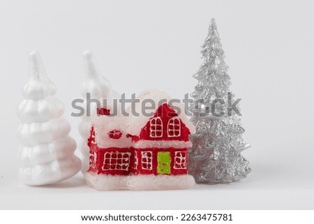 Christmas scene, miniature dacha village. Christmas little red houses, deer and snowy fir trees on a white background. Festive modern decorations.