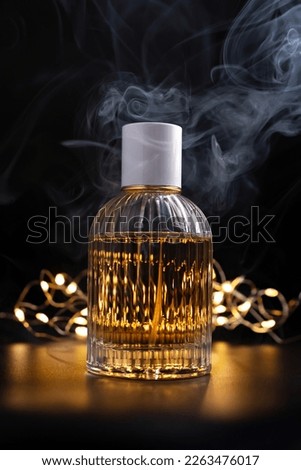 Mock-up of cosmetic product. Glass bottle of perfume with smoke on black background with shiny lights