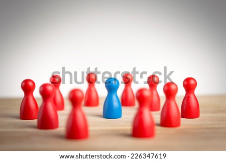 Surrounded by adversity or praised for being different concept with figurines Royalty-Free Stock Photo #226347619