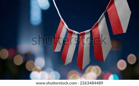 A garland of Poland national flags on an abstract blurred background.
