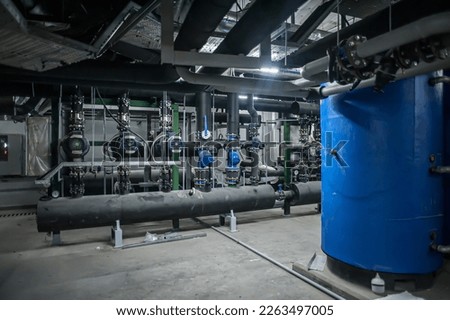Huge industrial boiler services and air handling unit in the ventilation plant room with ductworks and insulated pipelines Royalty-Free Stock Photo #2263497005
