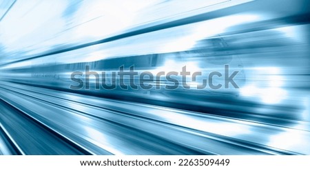 Blue high speed train runs on rail tracks - The train is going too fast as a result the air pressure is causing too much heat at the front Royalty-Free Stock Photo #2263509449