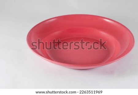 A red plastic plate isolated on a white background.