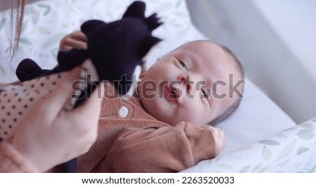 Newborn looking at the white and black toy. What newborn see, contrast, black and white concept Royalty-Free Stock Photo #2263520033