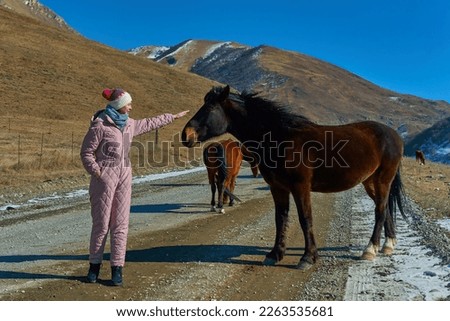 girl with horse in winter in the mountains