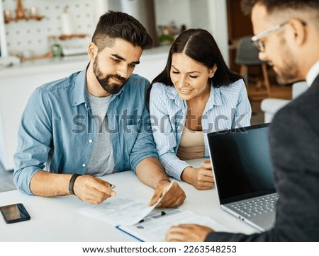 young couple deal contract real estate investment business agreement agent document signing meeting Royalty-Free Stock Photo #2263548253
