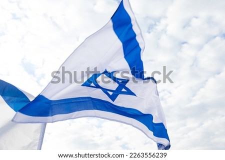 The Israeli flag flies in the sky