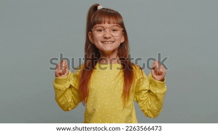 Young preteen child girl kid shouting, raising fists in gesture I did it, celebrating success, winning, birthday, lottery jackpot goal achievemen. Little toddler children isolated on gray background
