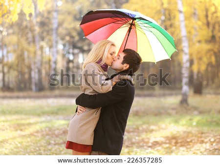 Love, relationship, engagement and people concept - happy kissing couple in love outdoors in autumn park