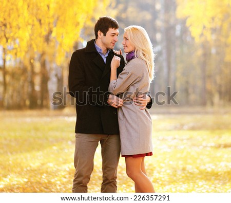 Autumn, love, relationships and people concept - lovely young couple in love outdoors in sunny autumn park