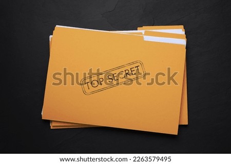 Yellow file with documents and Top Secret stamp on black table, top view Royalty-Free Stock Photo #2263579495