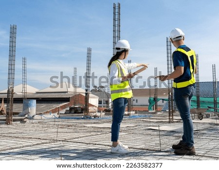 Teamwork of civil technician engineer and professional architect working together to inspect and discuss the infrastructure plan details of building construction progress at site