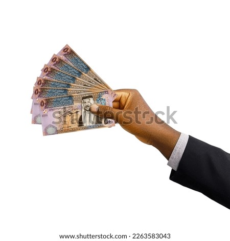 Black hand with suit holding 3D rendered Jordanian dinar notes isolated on white background Royalty-Free Stock Photo #2263583043