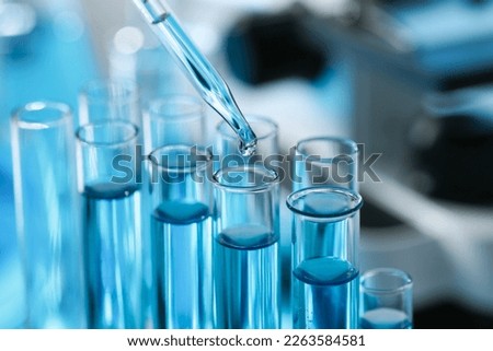 Dripping liquid from pipette into test tube in laboratory, closeup Royalty-Free Stock Photo #2263584581