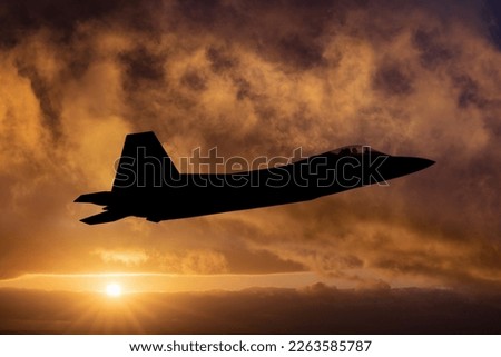 Fighter Plane in Flight at sunset. Fast Jet military interceptor on a combat mission silhouetted against dramatic sky Royalty-Free Stock Photo #2263585787