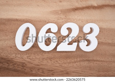 White number 0623 on a brown and light brown wooden background.