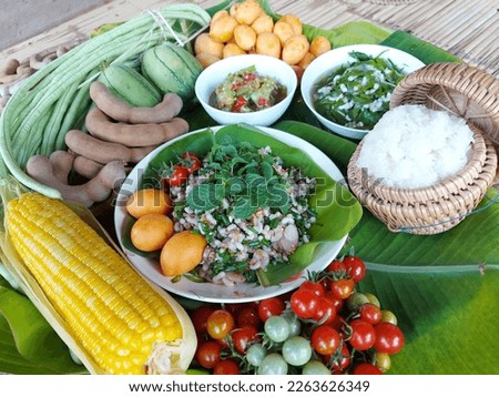 A dish of ant eggs salad or Koi Khai Mod Daeng, the popular local food in Isan, Thailand. A small bowl of ant eggs soup mixed with local vegetable is placed by the sticky rice container Royalty-Free Stock Photo #2263626349