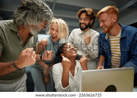 In the modern office a group of colleagues of different ages and ranks celebrate a business success. Workers from the same team rejoice at the company's progress. Happy entrepreneurial people. Royalty-Free Stock Photo #2263626725