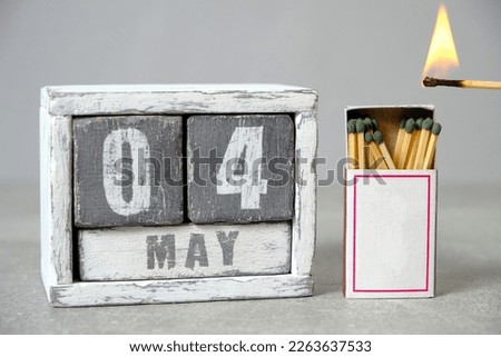 May 4 calendar.Open box of matches and an open flame held up to it.Concept for International Day Firefighters