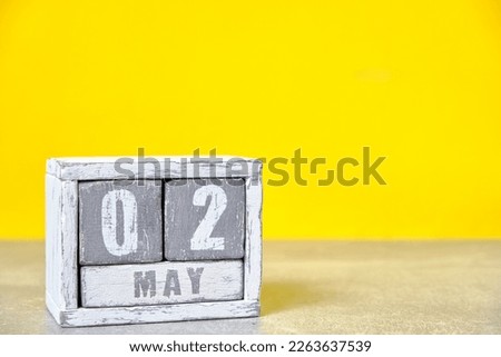 May 2, Wooden desktop calendar yellow background.Spring month depicted on cubes.Place for your ideas