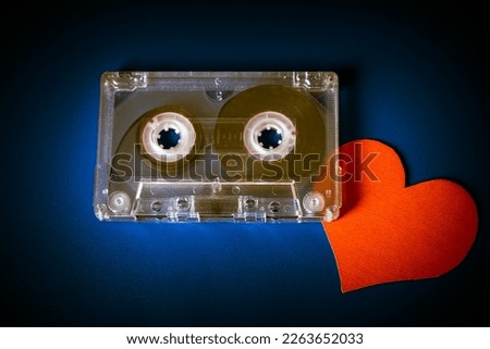 Old Audio Tape Cassette with a Red Heart on the Dark Background closeup