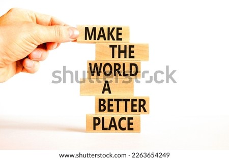 Make a better world symbol. Concept words Make the world a better place on wooden blocks. Beautiful white table white background. Businessman hand. Business make a better world concept. Copy space.