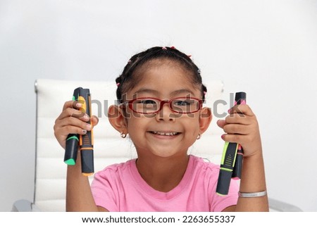 4-year-old brunette Latina girl with autism spectrum disorder ASD like Asperger, Rett and Heller draws at a desk, plays with colors alone antisocial Royalty-Free Stock Photo #2263655337