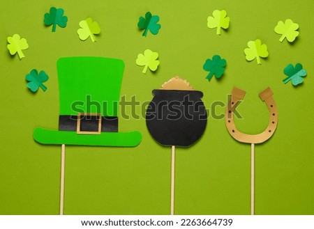 St. patrick's day celebration decor. Paper art. Leprechaun hat, bowler hat with gold, horseshoe and leprechaun on a green background. Theme party