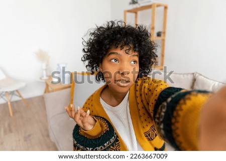 Happy african american teen girl blogger smiling face talking to webcam recording vlog. Social media influencer woman streaming making video call at home. Headshot portrait selfie webcamera view Royalty-Free Stock Photo #2263667009