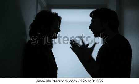 Young parents Arguing and Fighting. Domestic Violence and Emotional abuse Scene. Stressed man and aggressive Man yelling at wife at Dark Hallway of Apartment. Making peace with child Royalty-Free Stock Photo #2263681359