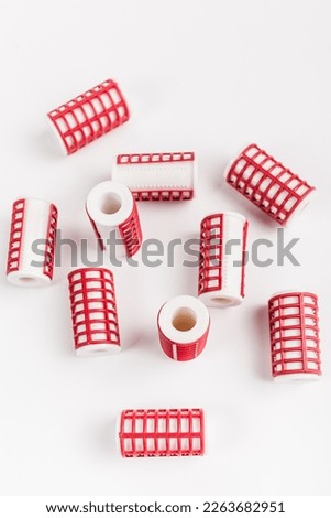 a set of several unfolded women's hair curlers on an isolated white background