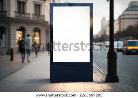 Blank city format (LightPoster, CityLight) banner pylon on the sidewalk mockup. Billboard in the city center mock up. Blurred background, focus on foreground, copy space Royalty-Free Stock Photo #2263689285