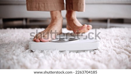 Low Section Of Woman Standing On Weight Scale Royalty-Free Stock Photo #2263704185