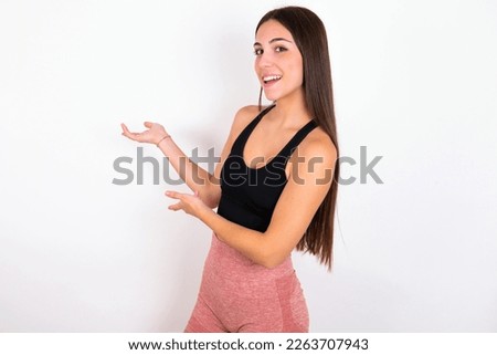 young woman wearing sportswear over white studio background Inviting to enter smiling natural with open hands. Welcome sign.