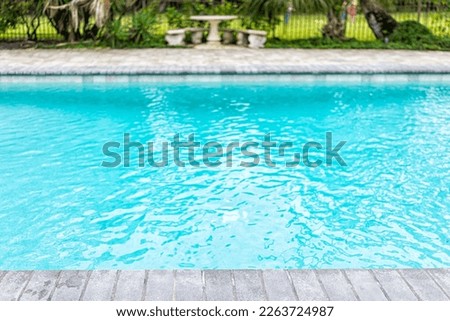 Generic blue saltwater pool in tropical setting with closeup of water and nobody in garden as copy space background Royalty-Free Stock Photo #2263724987
