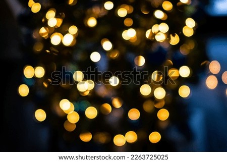 Blue and golden yellow bokeh circles from New Year Christmas tree lights illuminations with defocused blurred view at night