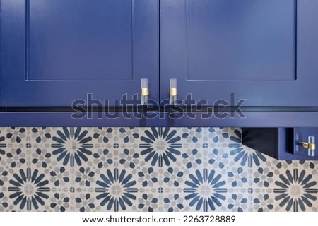 Closeup of Blue cabinetry with blue and grey flower pattern tile backsplash Royalty-Free Stock Photo #2263728889