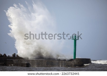 large destructive storm surge breaks through the breakwater in the harbor Royalty-Free Stock Photo #2263732441